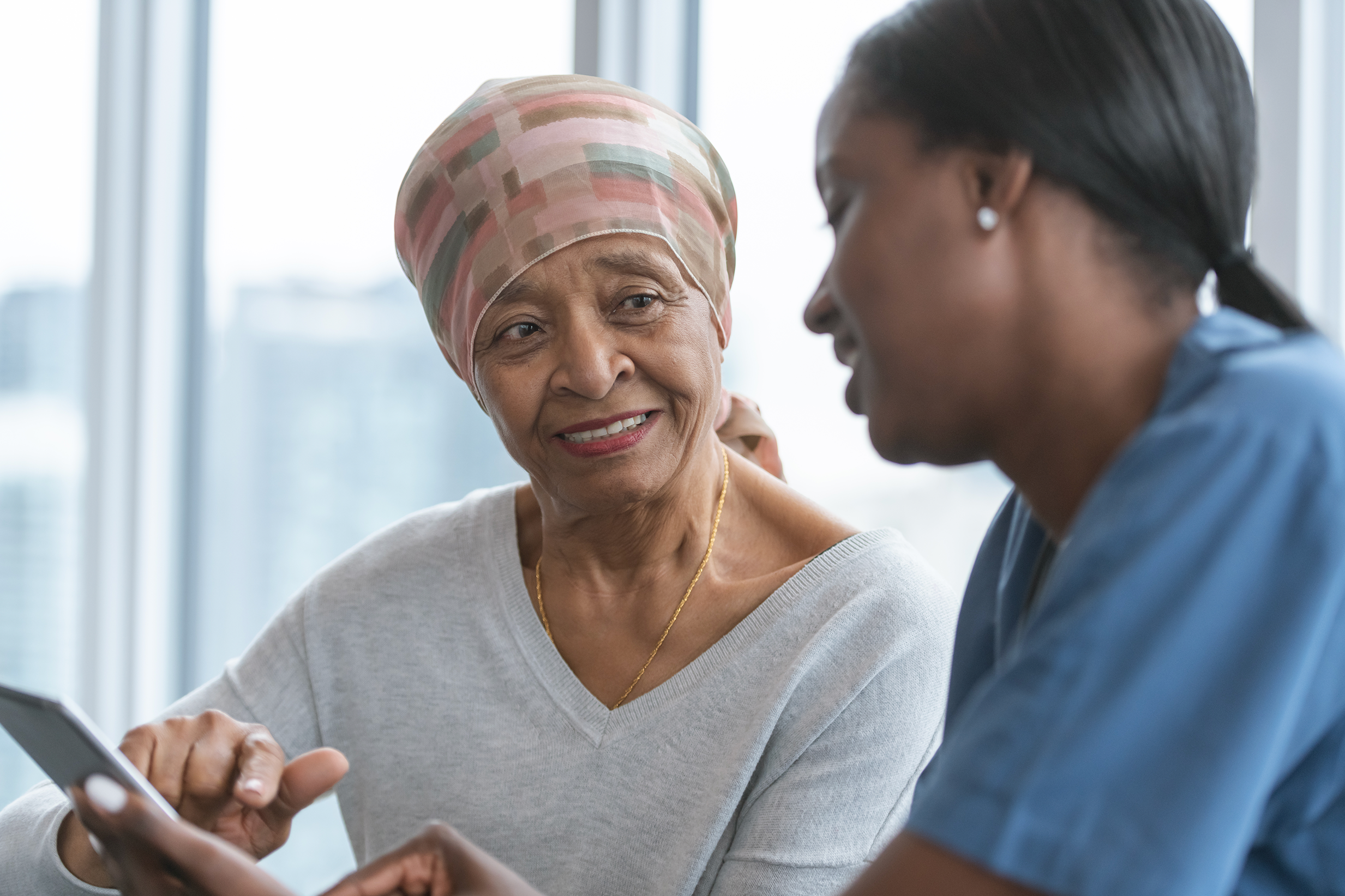 Older Black woman in conversation with younger Black healthcare worker